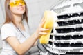 Hand woman car wash foam with yellow sponge headlights Royalty Free Stock Photo