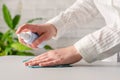 Hand of woman cleaning reception desk. disinfection spray, small towel. Protection from bacteria and virus. Keeping health of gues