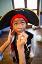 Hand of woman drawing mustache on boy face