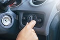 Hand driver turn on light switch in car Royalty Free Stock Photo