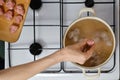 Hand of woman dropping meatballs in boiling water Royalty Free Stock Photo