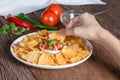 Hand of woman eating tortilla chips dip tomato salsa. Royalty Free Stock Photo