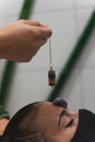 Hand of a woman healer applying reiki and energy therapies through the use of a pendulum