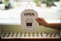 Hand woman hold open sign broad through the door glass. OPEN sign board through the glass of store window. text wooden board door Royalty Free Stock Photo