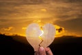 Hand woman holding broken heart paper shape on blur sunset nature mountain Royalty Free Stock Photo