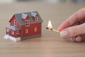 Hand of woman holding burning match near two-story house Royalty Free Stock Photo