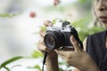 Hand woman holding the camera Taking pictures Background blurry trees Royalty Free Stock Photo
