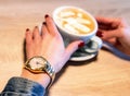 Hand of woman holding cup of cappucinno Royalty Free Stock Photo