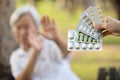 Hand of woman holding medicine tablets,capsules,show lots of medication,old elderly on blurred background,senior people raise