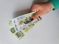 hand of a woman holding mexican banknotes of 200 pesos