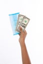 Hand of woman holding surgical face mask and dollar banknotes, money, cash, studio light shooting isolated