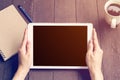 Hand woman holding tablet working on wood table in coffee shop with vintage filter. Royalty Free Stock Photo