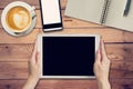 Hand woman holding tablet working on wood table in coffee shop w Royalty Free Stock Photo