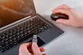 Hand of a woman holding a USB device connected to Laptop computer on white table