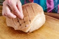 Hand of a woman larding the rind of a raw roast pork with cloves on a wooden kitchen board to cook a delicious Christmas ham, copy