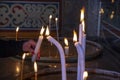 The hand of a woman lighting a candle in the church. Royalty Free Stock Photo