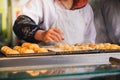 Hand of woman making takoyaki.