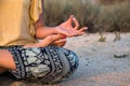 Hand of a woman meditating in a yoga pose on the beach at sunset Royalty Free Stock Photo