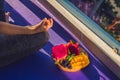 Hand of a woman meditating in a yoga pose, sitting in lotus with fruits in front of her dragon fruit, mango and mulberry