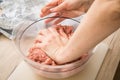 Hand of woman mixing mixed minced meat of pork and beef with ground spices in bowl on cutting board for cooking in domestic