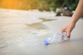 Hand woman picking up plastic bottle cleaning on the beach