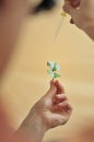 Hand of woman with pipette with drop of water over the leaf Royalty Free Stock Photo