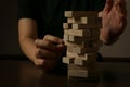 Hand of woman planning risk and strategy in business.Businessman gambling placing wooden block on a tower and protect it