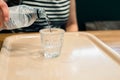 Hand of woman pouring bottle of water into glass. Royalty Free Stock Photo