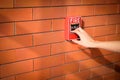 Hand of woman is pulling fire alarm on the brick wall Royalty Free Stock Photo