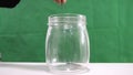 Hand of woman putting coin to glass jar for money and finacial concept