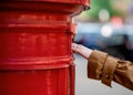 Hand  of woman sending letter in a red box Royalty Free Stock Photo