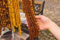 Hand of woman with shiny womanly amber necklaces on stall at the bazaar