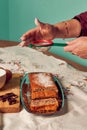 Hand of a woman with a sieve pours flour into a homemade sponge cake