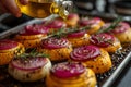 Hand of woman sprinkling olive oil on sliced onion