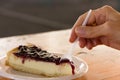 Hand of woman taking a piece of blueberry cheesecake