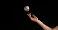 Hand of Woman Throwing a Ball of Baseball against Black Background Royalty Free Stock Photo