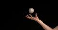 Hand of Woman Throwing a Ball of Baseball against Black Background Royalty Free Stock Photo