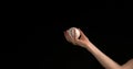 Hand of Woman Throwing a Ball of Baseball against Black Background Royalty Free Stock Photo