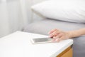 Hand of woman turn off alarm on call mobile phone while wake up after sleep relax Royalty Free Stock Photo