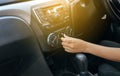 Hand of woman turning on car air conditioning system,Button on dashboard in car panel Royalty Free Stock Photo