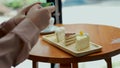 Hand of woman use smartphone take a picture cake