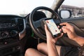 Hand of woman using smartphone with gps navigator map application in SUV car