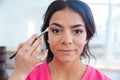 Hand of woman visagist applying eyeshadow to pretty young model