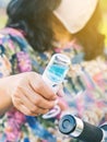 Hand of woman wear face mask spraying alcohol nano mist sprayer on handlebar Motorcycle to prevent infection of Corona virusCovid Royalty Free Stock Photo