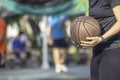 Hand of a woman wearing a watch And holding old basketball