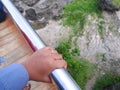The hand of the woman who is holding the iron barrier of the bridge Royalty Free Stock Photo