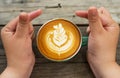 Hand women with cappuccino coffee in a green cup on wooden Royalty Free Stock Photo