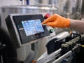 Hand of a worker touching the screen of an electronic machine of a brewery