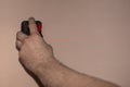 In the hand of the worker, the laser level shines with a red beam a line on the wall