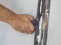 The hand of a worker with a long spatula that works on the wall. Interior work, construction concept. selective focus. Focus on